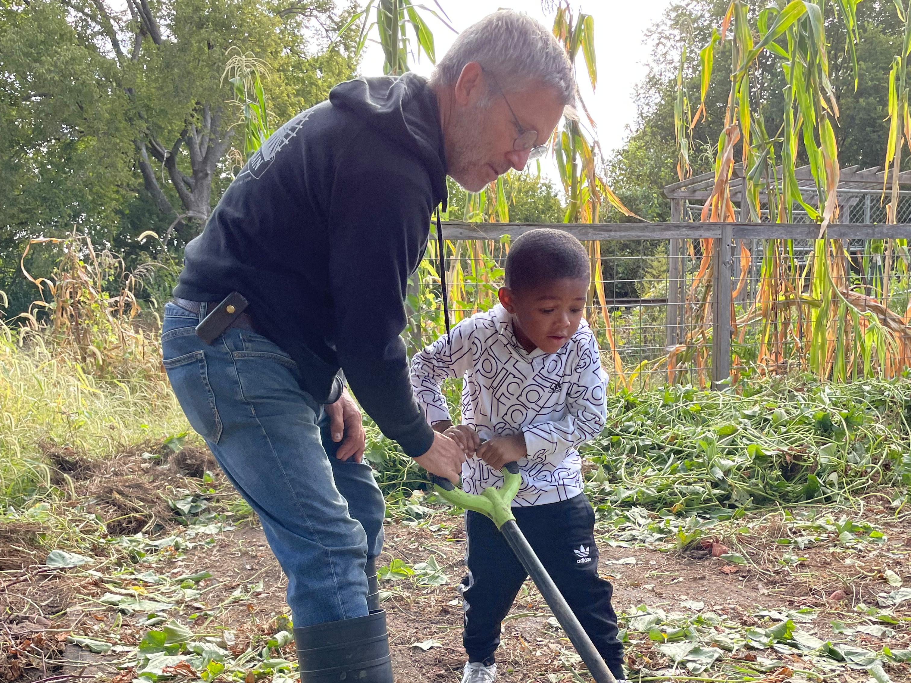 Adult Helping Child with Shovel